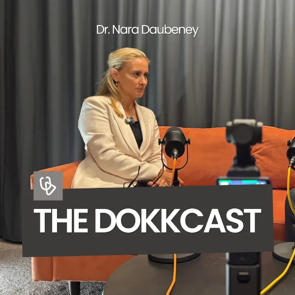 The Dokkcast cover art: a guest seated on an orange sofa beside a podcast microphone, with a camera in the foreground